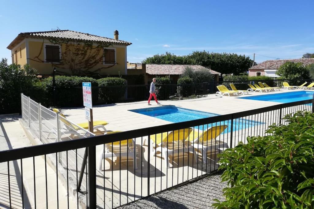 un homme marchant près d'une piscine avec des chaises dans l'établissement Studiowillangel, à Régusse