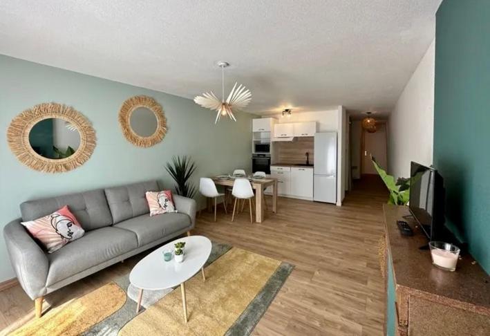 a living room with a couch and a table at Confort & style dans ce joli appartement de 44 m2, chambre séparée, PLEIN CENTRE de Dole in Dole