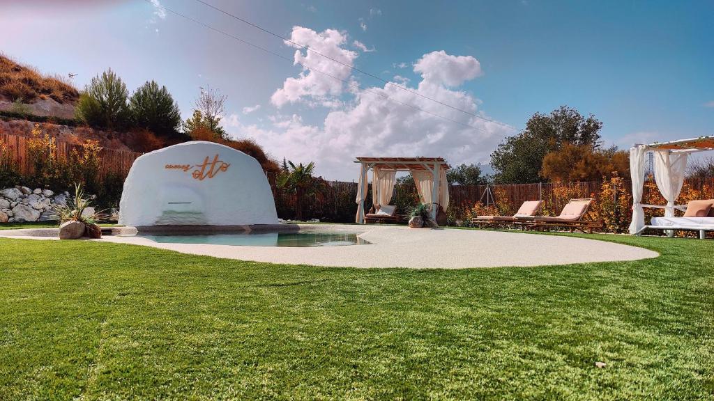 a backyard with a pool in the grass at Complejo Cuevas Otto in Baza