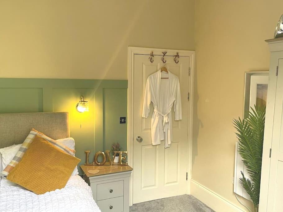 a bedroom with a white robe hanging on a door at Sunny View in Aberystwyth