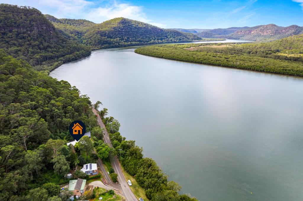 an aerial view of a river with a house at Secluded Waterfront House on Rainforest Acerage in Wisemans Ferry