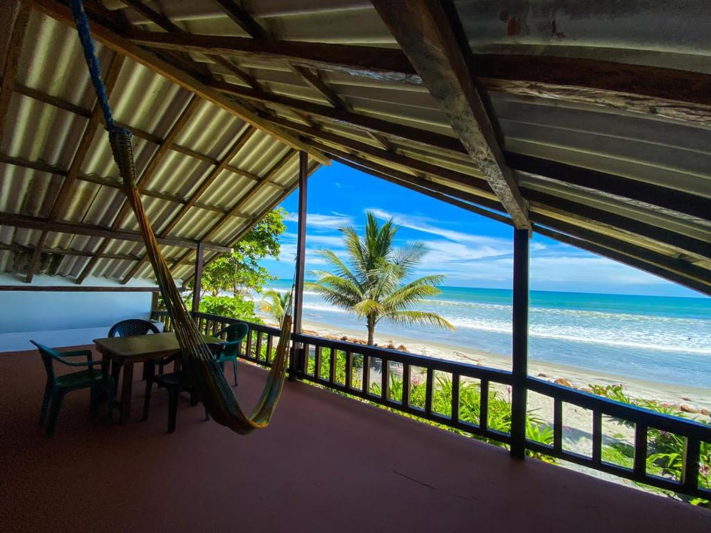 a room with a hammock and a view of the beach at Mompiche Island Hostel in Mompiche