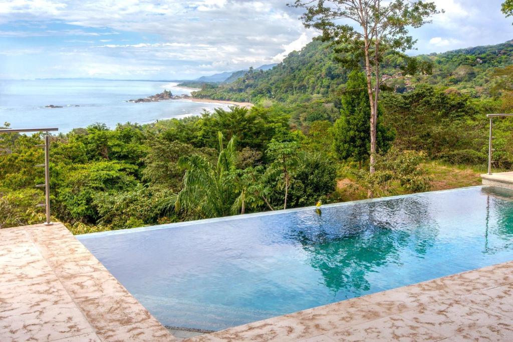 a swimming pool with a view of the ocean at Luxe 4 Bdrm Villa with Epic OceanView & Infinity Pool in Dominicalito