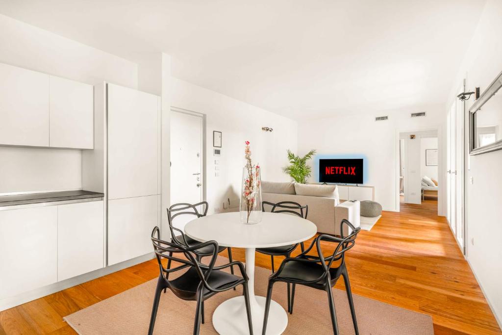 a white living room with a table and chairs at Modern with Terrace & Garage - NDP Rent in Milan