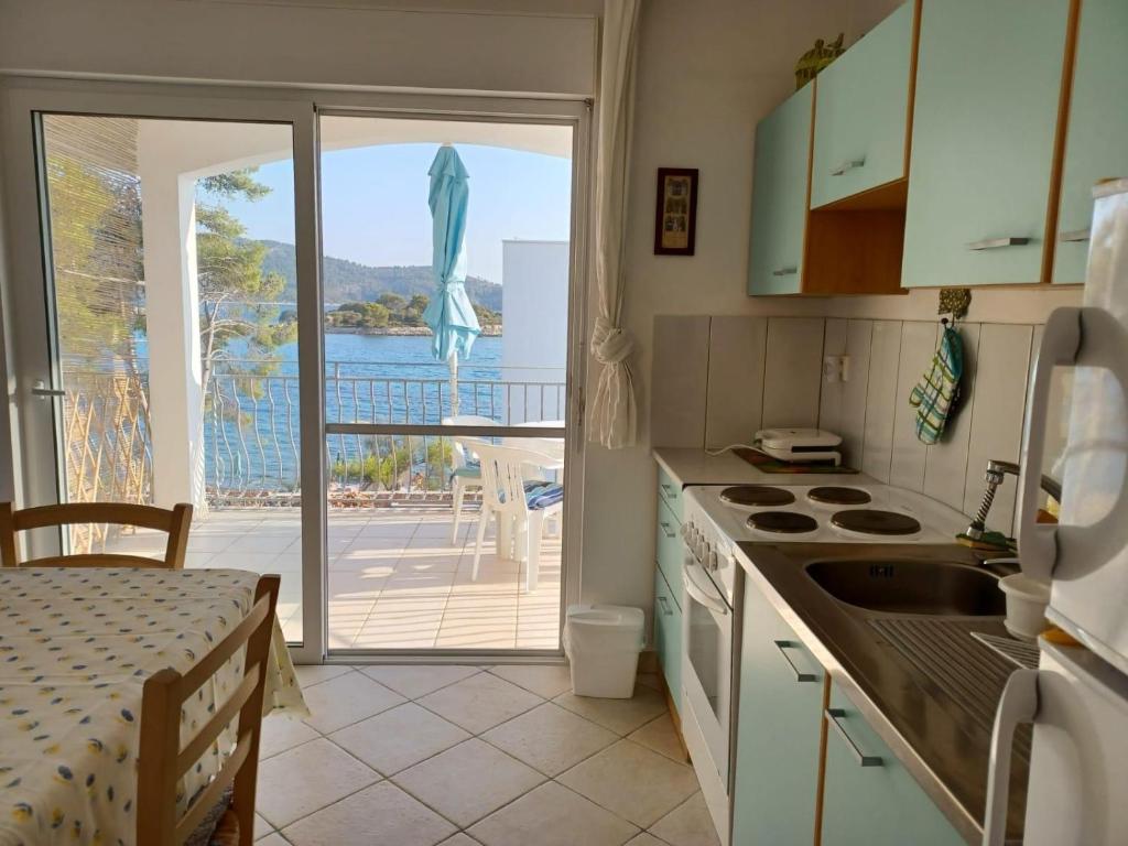 d'une cuisine avec vue sur l'océan et d'un balcon. dans l'établissement Dalmas apartmani, à Vela Luka