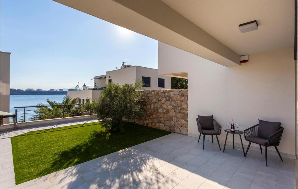 a patio with a view of the water from a house at 2 Bedroom Stunning Apartment In Omisalj in Omišalj