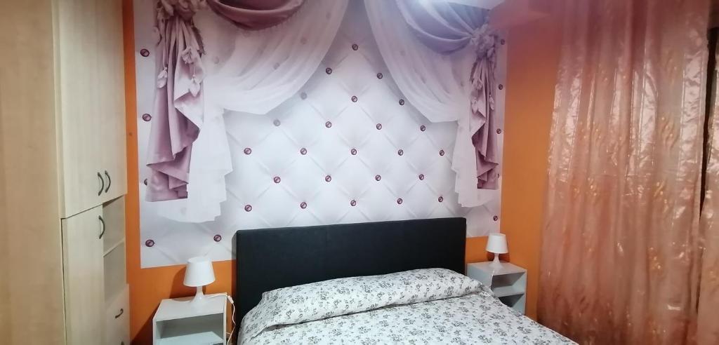 een slaapkamer met een bed en een groot hoofdeinde bij Céline in Genua