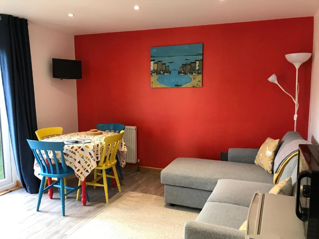 a living room with a table and a couch at Woodpecker Glamping Cabin in Bodmin