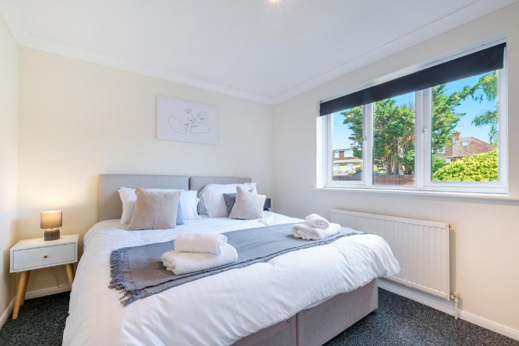 a bedroom with a large bed with towels on it at Harry Potter, Warner Brothers Apartment - Watford Junction - Watford FC - Free Parking in Watford