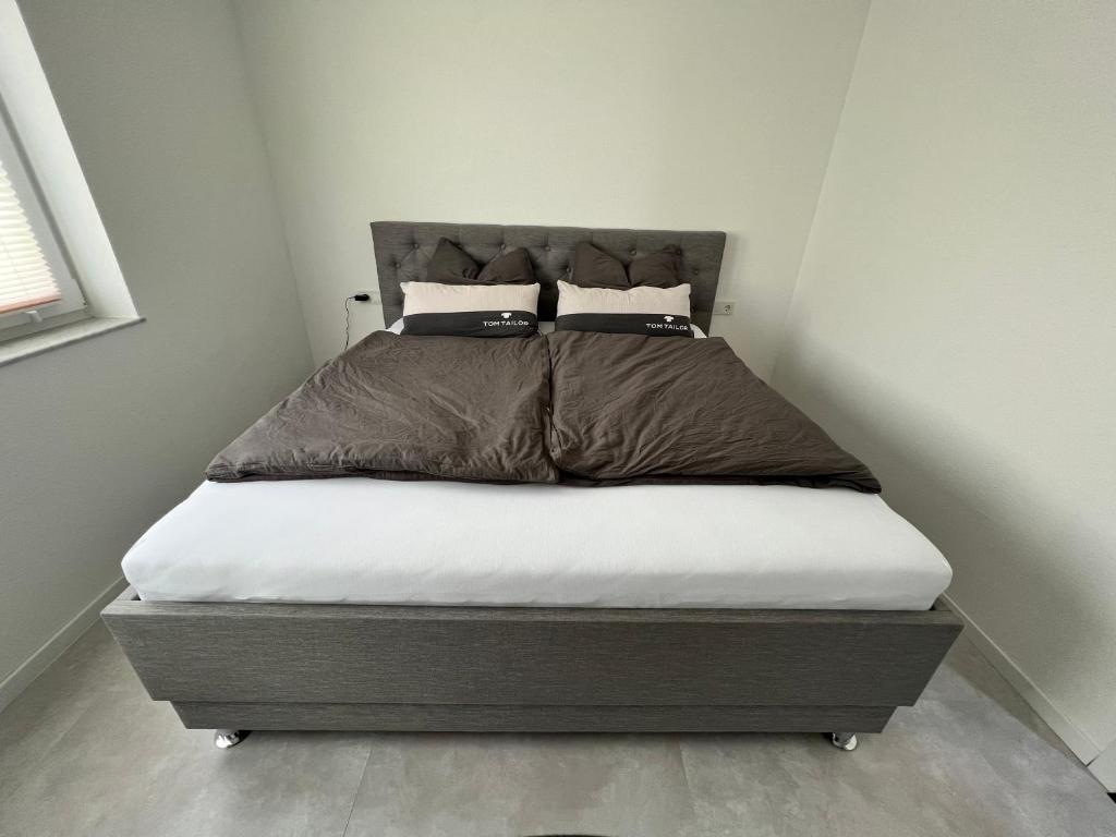 ein Bett mit zwei Kissen darauf in einem Schlafzimmer in der Unterkunft Feel like Home 1 in Biberach an der Riß