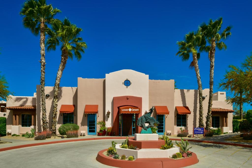 un bâtiment avec des palmiers en face de celui-ci dans l'établissement Lodge On The Desert, à Tucson
