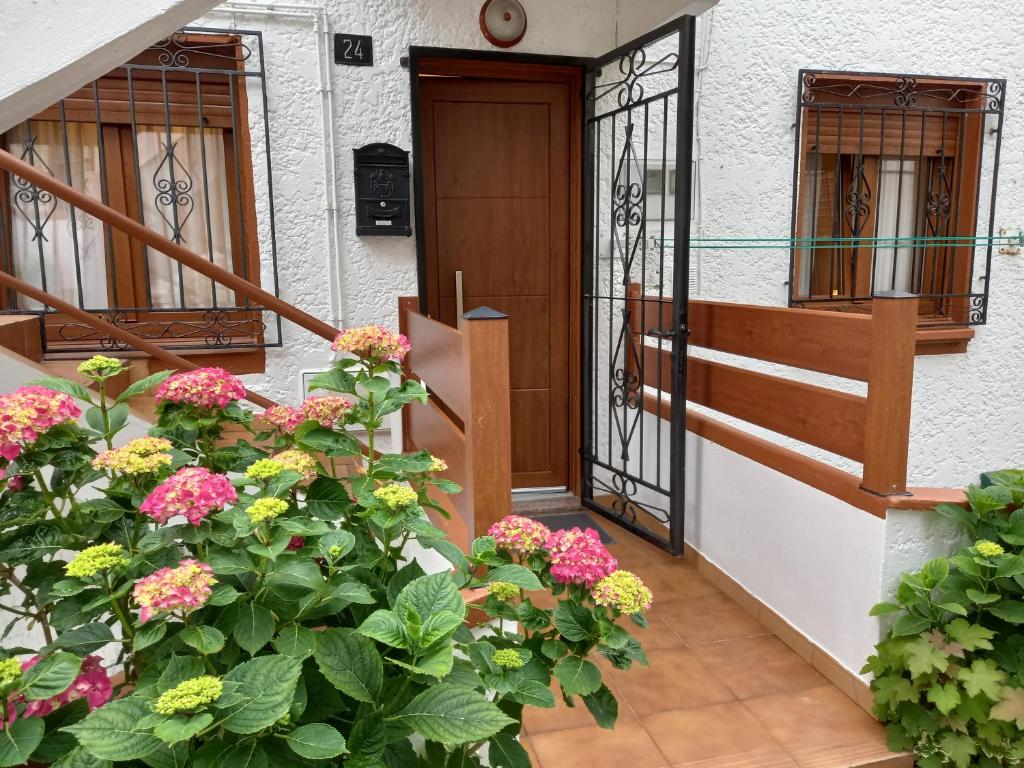 una porta d'ingresso di una casa con fiori di Casa Anita a Luarca