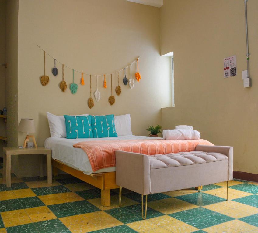 a bedroom with a bed and a couch in a room at Bokatrip El Llano in Oaxaca City
