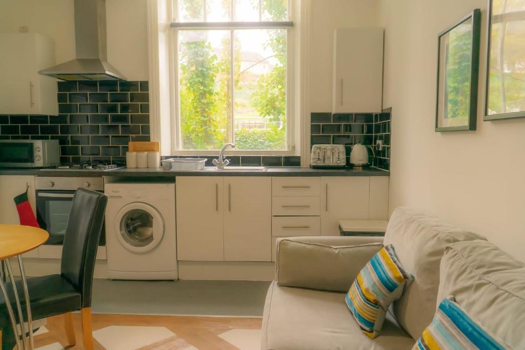 a kitchen with a couch and a washing machine at Great offers on Long Stays!! LaLuNa Apartments in Gateshead