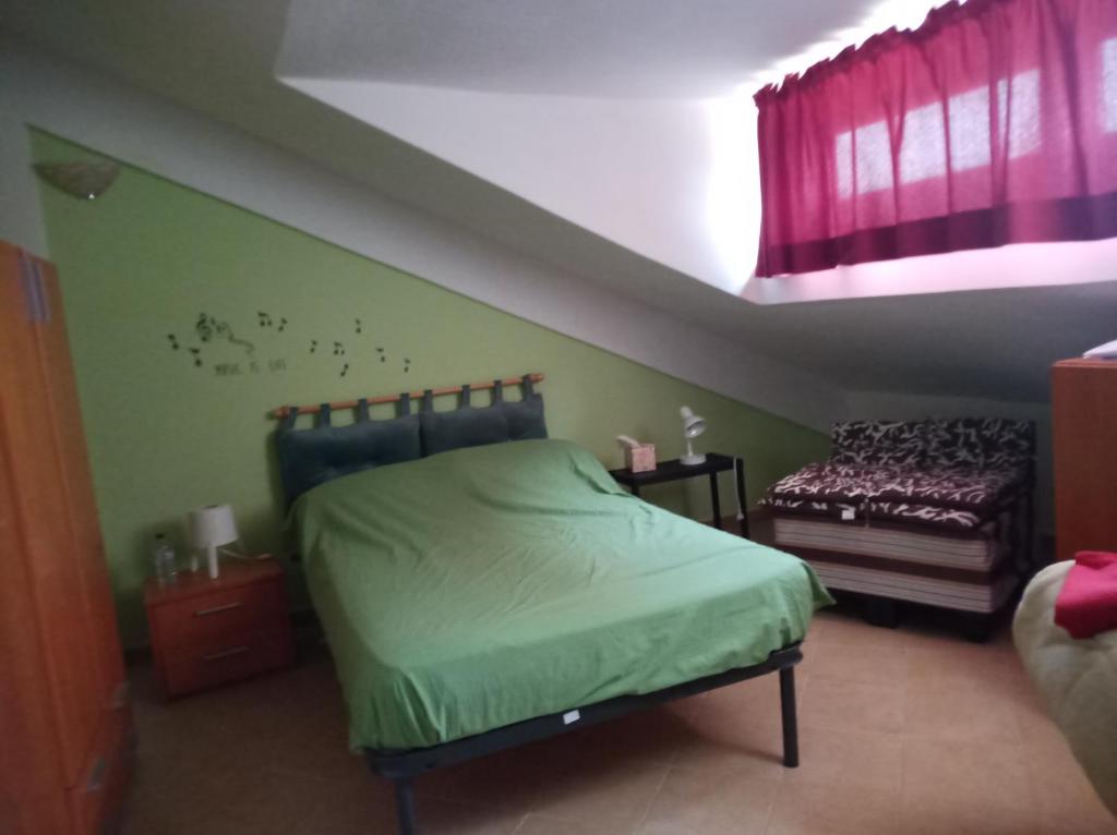 - une chambre avec un lit vert et une fenêtre dans l'établissement Casa Betti, à Palerme