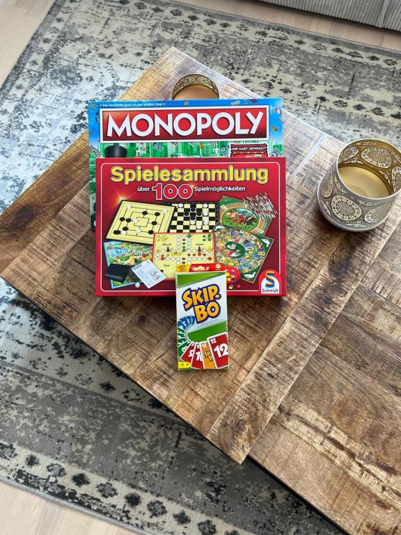 ein Monopol-Brettspiel und eine Schachtel und eine Tasse Kaffee in der Unterkunft UNiQE I Stilvolle 115qm I Terrasse I BBQ in Feldafing