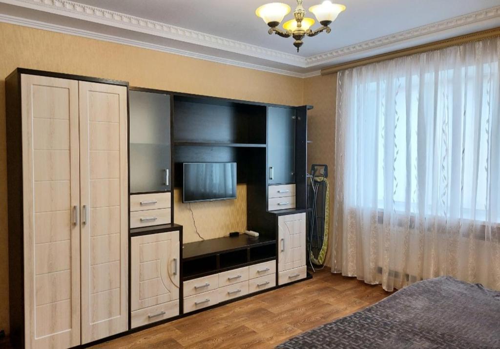 um quarto com um grande centro de entretenimento com uma televisão em Апартаменты, 2 комн. 6 мест em Kirovohrad