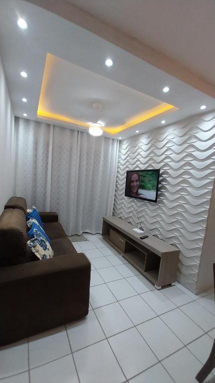 een woonkamer met een bank en een flatscreen-tv bij APTO Cheio de Estilo in São Luís