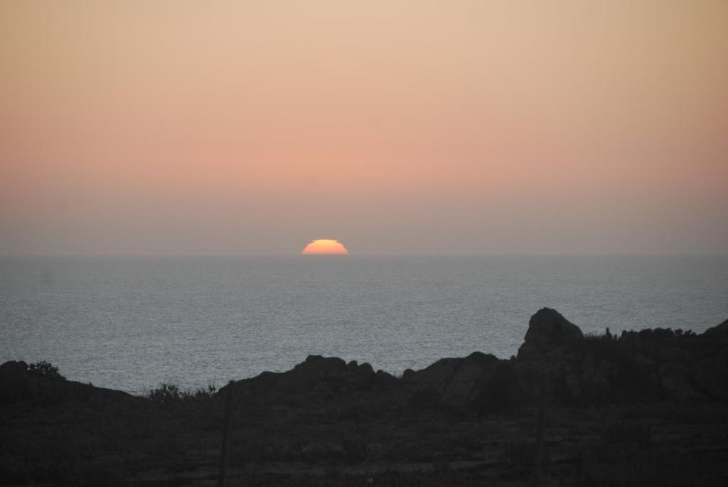 una puesta de sol sobre el océano con el sol en el horizonte en Cabanas Las Hualas, en Punta de Choros