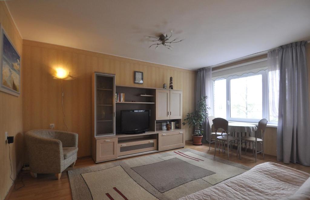 a living room with a television and a table and chairs at Bastrakovi Apartment in Narva