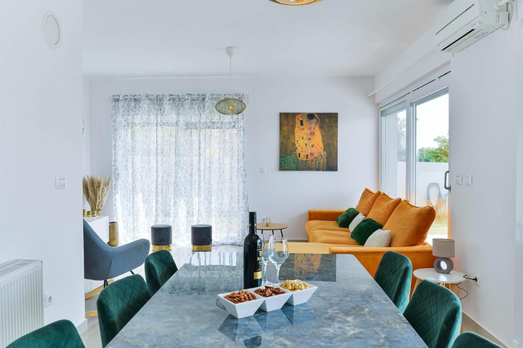 a living room with a glass table and green chairs at LUXURY MARIJANA APARTMENT in Privlaka