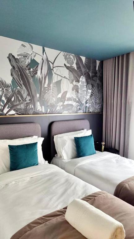 a hotel room with two beds and a mural at Eleven by Warren Collection in Sliema