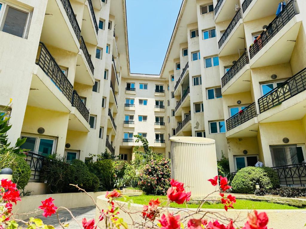 an apartment building with red flowers in front of it at Partition Near Metro G-19 P02 in Dubai