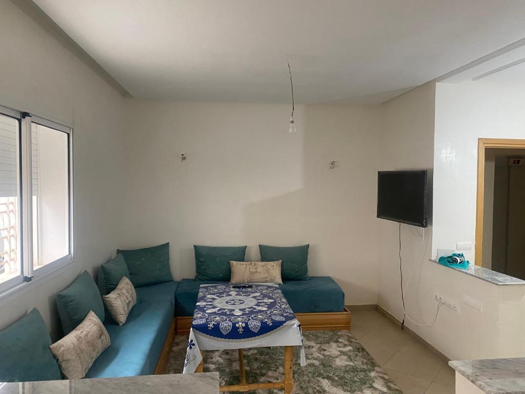 - un salon avec un canapé bleu et une table dans l'établissement Appartement neuf meublé dans le Centre d'Agadir, à Agadir