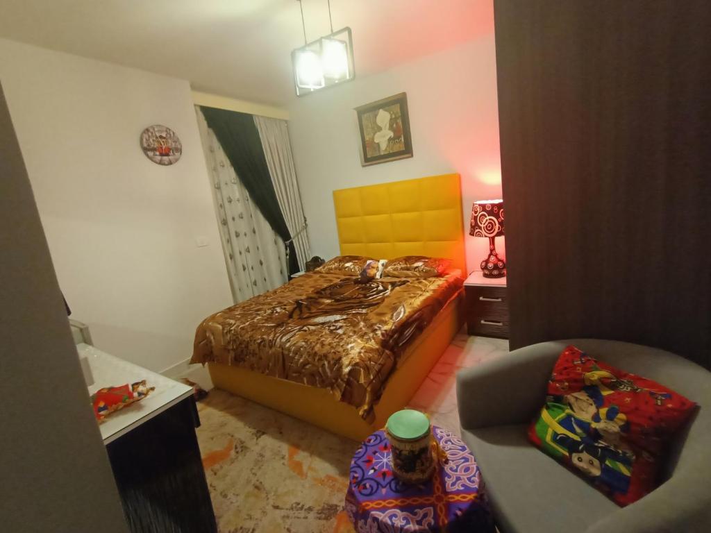 1 dormitorio pequeño con 1 cama y 1 silla en بورتو سعيد, en `Ezbet Shalabi el-Rûdi