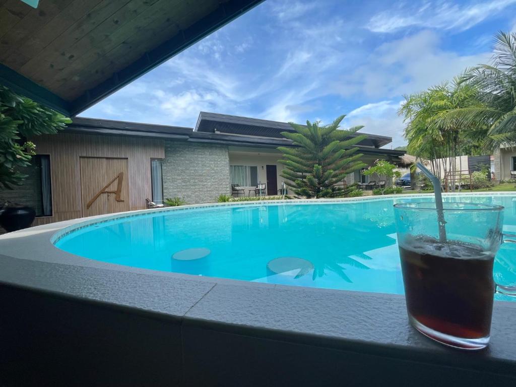 - une boisson assise sur une table à côté d'une piscine dans l'établissement Ariella Mangrove & Eco Resort by Hiverooms, à Bulalacaw