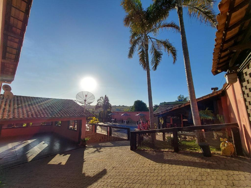 un patio con palmeras y una pista de tenis en Pousada Estância Tertúlia, en São Tiago