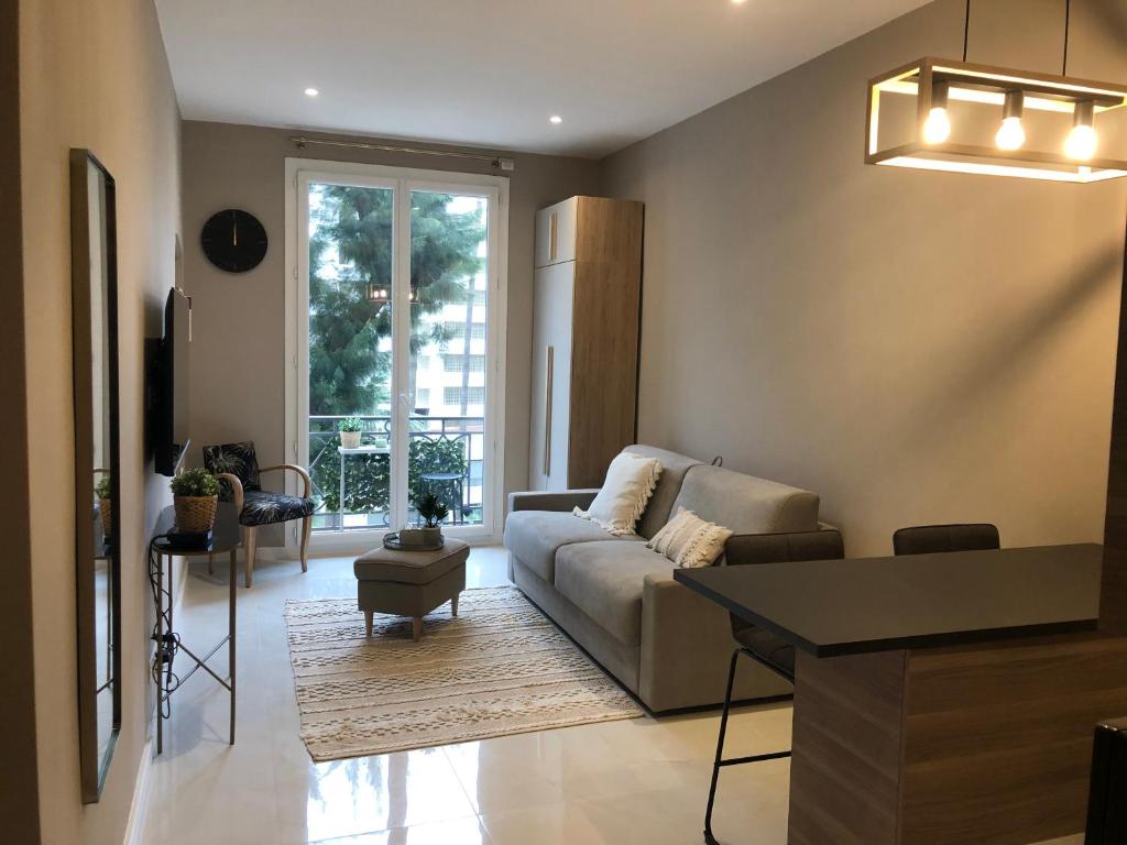 un salon avec un canapé et une table dans l'établissement Boulevard de la croisette PALAIS MIRAMAR, à Cannes