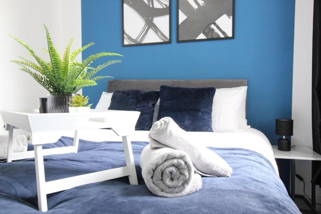 Un dormitorio con paredes azules y una cama con una toalla. en Amazing - 1BDR - Free Street Parking, en Wolverhampton