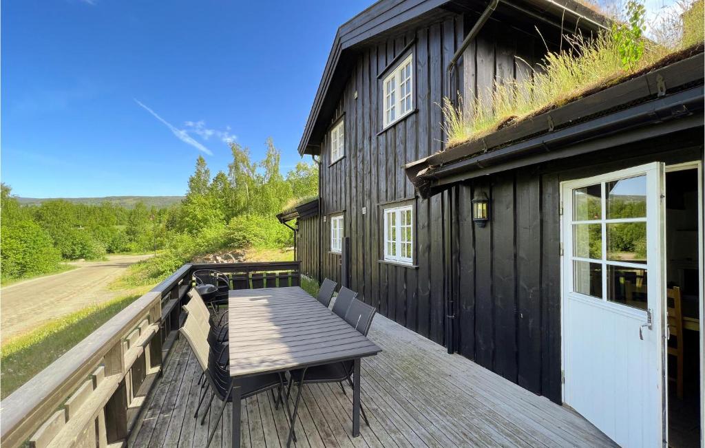 um deque de madeira com um banco ao lado de uma casa em Cozy Home In yer With House A Mountain View em Øyer