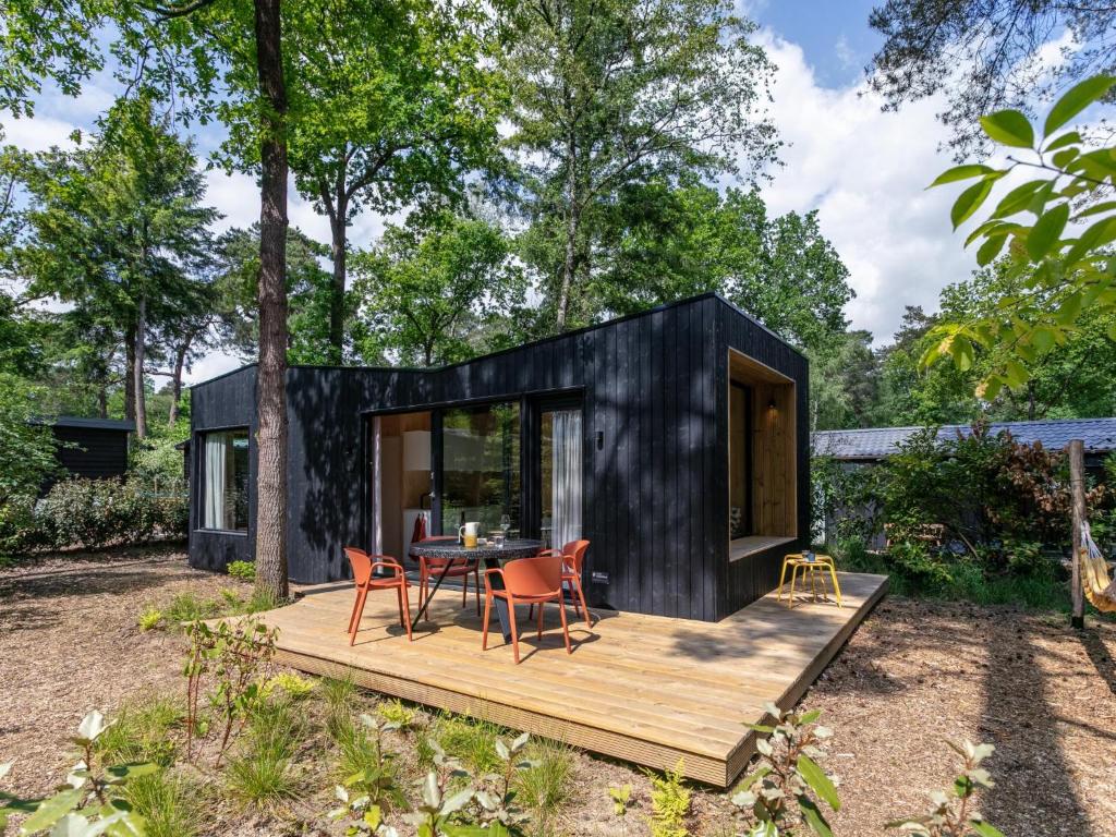 a black tiny house with a wooden deck at TED Tiny House in Nunspeet