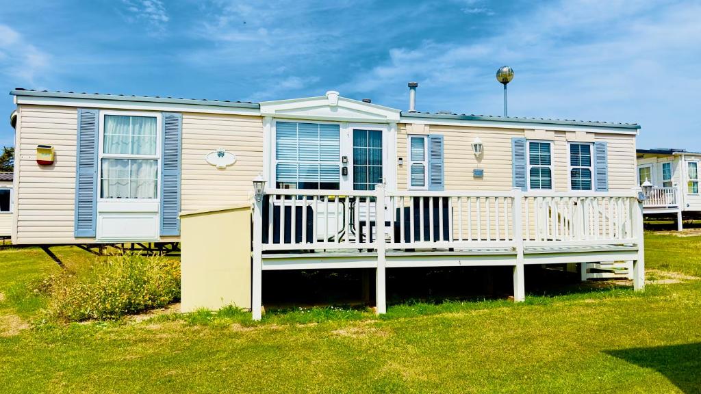 a mobile home with a porch and a deck at Freedom House in Clacton-on-Sea