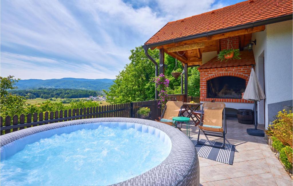 a hot tub on a patio with a fireplace at 2 Bedroom Nice Home In Donja Stubica in Donja Stubica