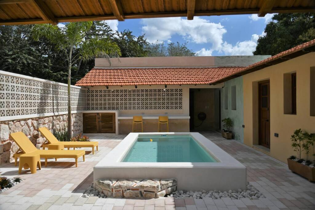 a backyard with a swimming pool and a house at Trilliza Azul in Campeche