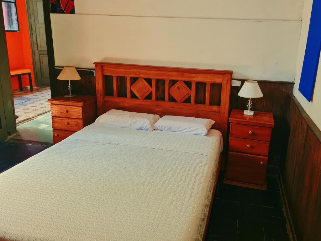 1 dormitorio con 1 cama de madera, 2 mesitas de noche y 2 lámparas en Como en casa, Mendoza en Godoy Cruz