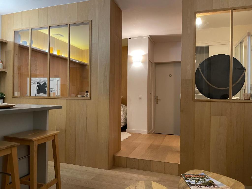 a kitchen with wooden walls and a counter and a table at La pointe Cap ferret in Lège-Cap-Ferret