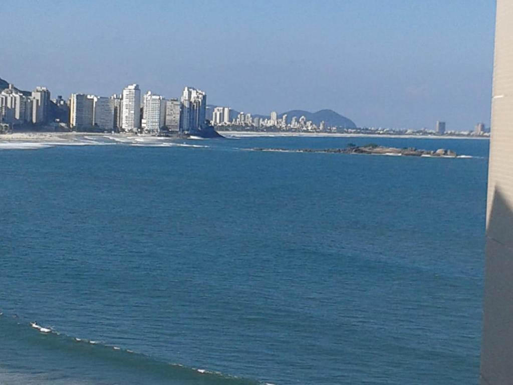 a view of the ocean with a city in the background at APTO FRENTE TOTAL P/ MAR in Guarujá