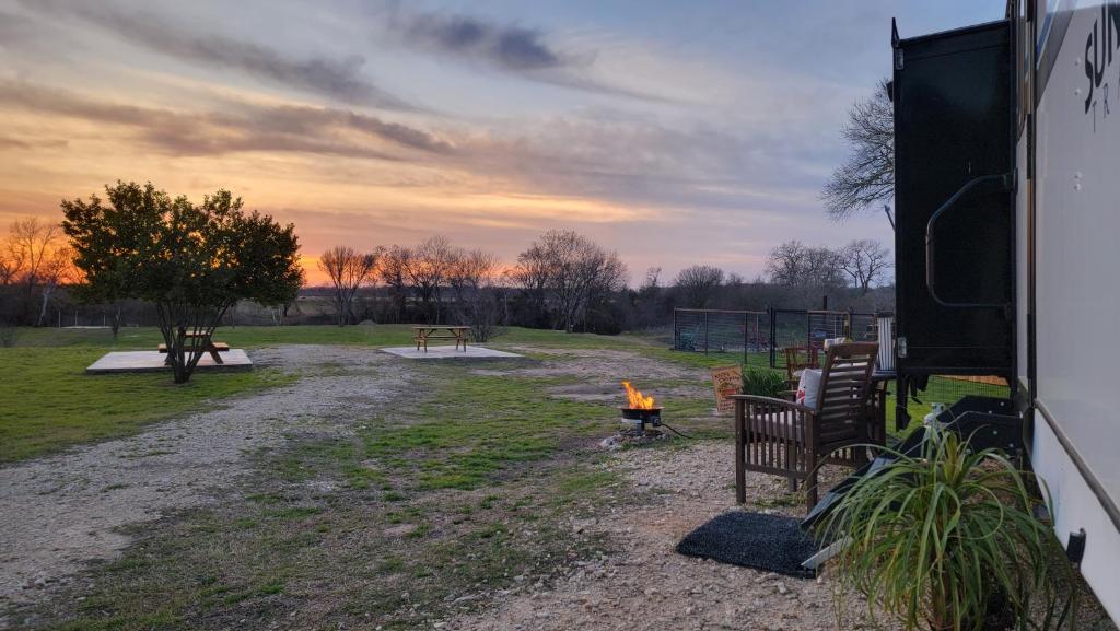 a campfire in a field with a table and benches at The River RV in Smithville