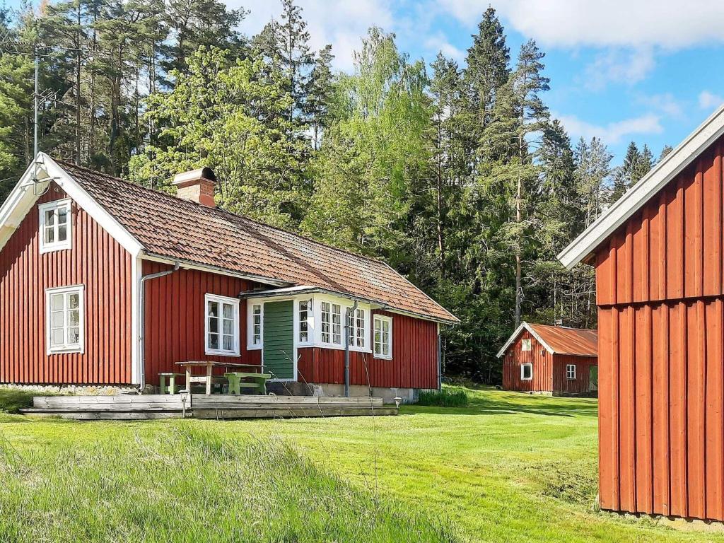 ein rotes Haus mit grüner Tür im Hof in der Unterkunft Holiday home Fjärås II in Fjärås