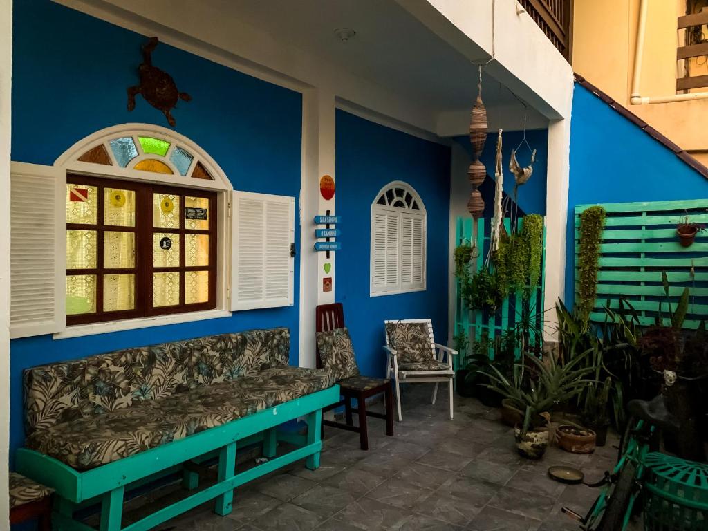 a living room with a couch against a blue wall at Guest House do Magoo in Arraial do Cabo