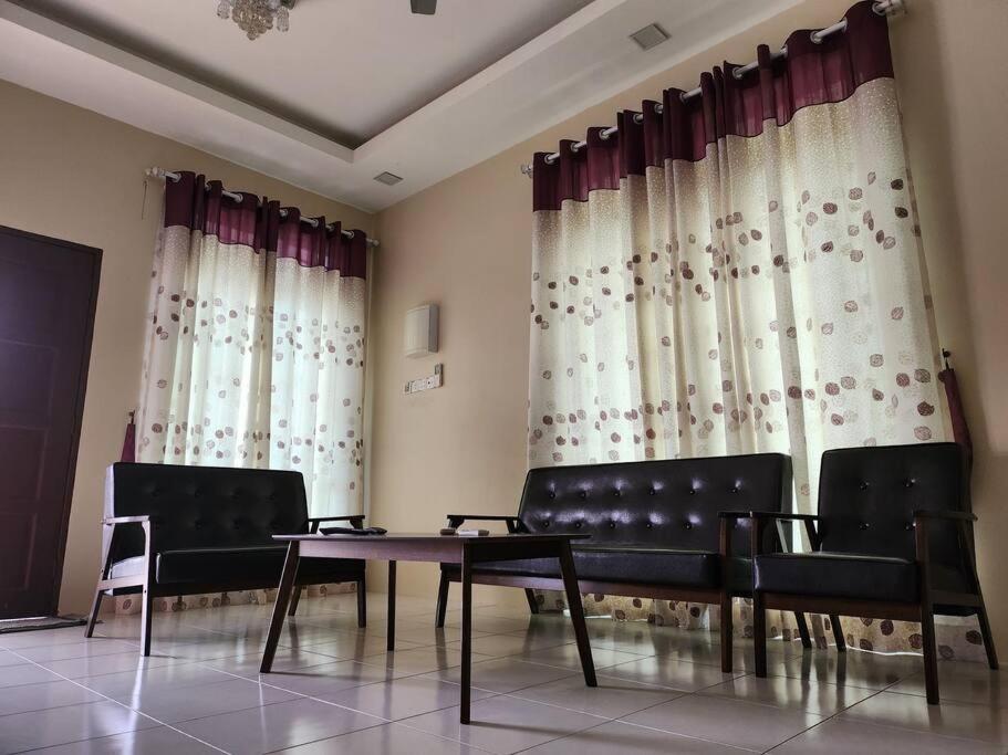 a waiting room with chairs and a table and curtains at Gated Family House- next to MRSM in Kampong Kawak