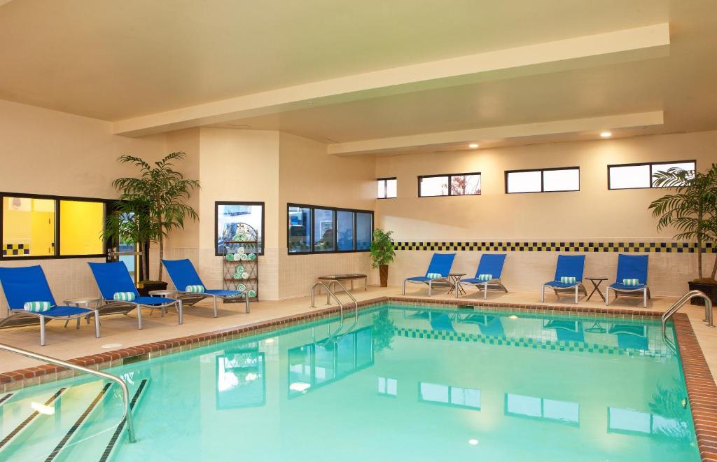 a swimming pool with blue chairs at Four Points Memphis Southwind in Memphis