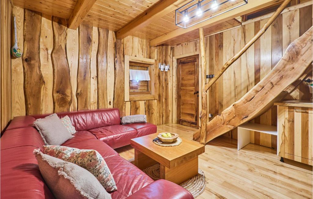 a living room with a red couch and wooden walls at Beautiful Home In Kraljev Vrh With Wifi in Kraljev Vrh