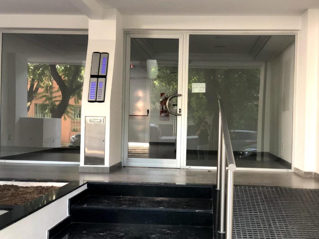 una entrada a una casa con puerta de cristal en Conesa Suite en General Sarmiento