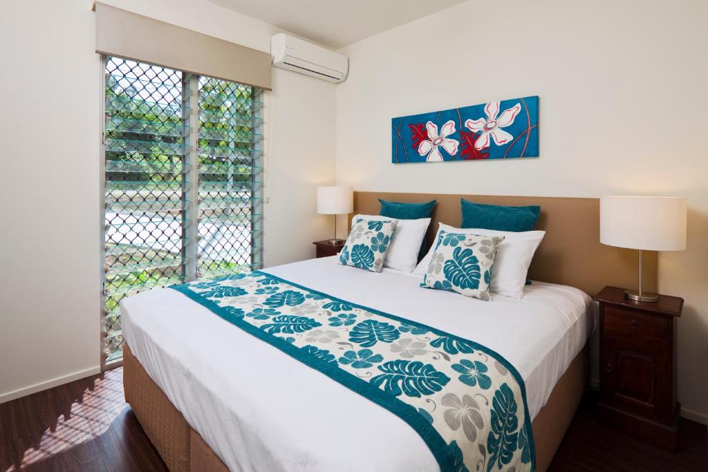 a bedroom with a large bed and a window at Island Villas in Thursday Island