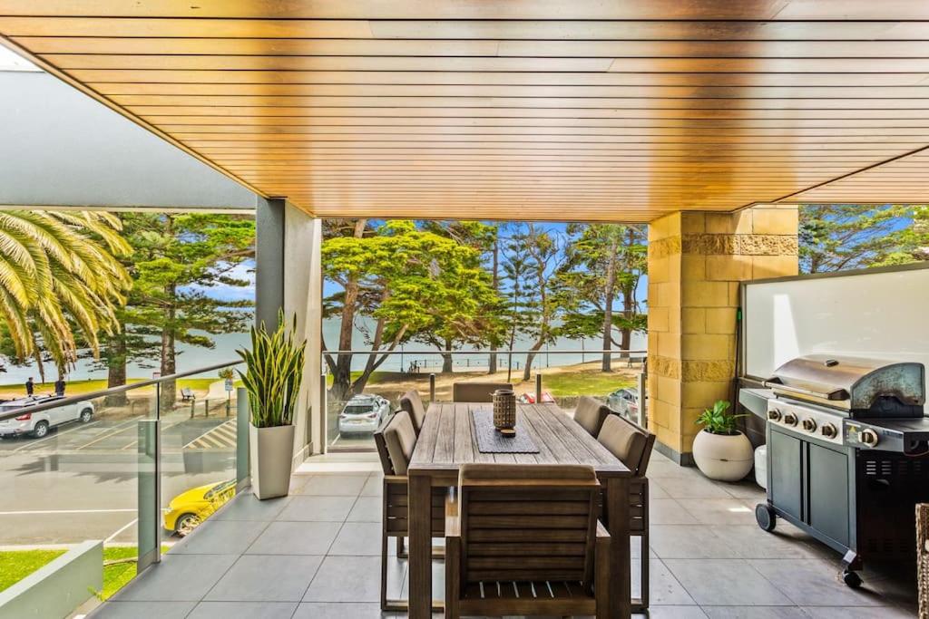 an outdoor patio with a table and a grill at Waterfront Apt Gorgeous Views in Cowes